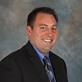 Eric Bowe Headshot in Dark Suite with Tie and blue shirt